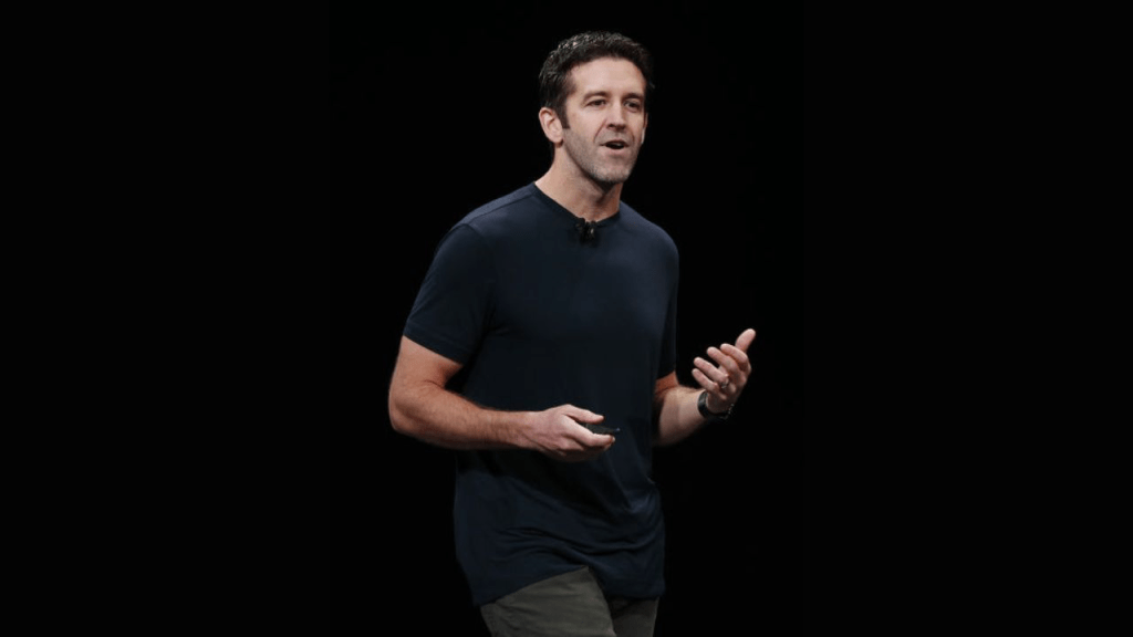 John Ternus, responsable de hardware en Apple, habla durante una presentación, vistiendo una camiseta oscura.