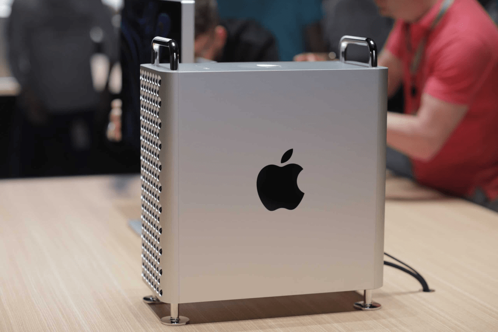 Prototipo de una computadora Mac Pro de Apple, mostrando un diseño cuadrado con perforaciones y el logo de Apple en la parte posterior.