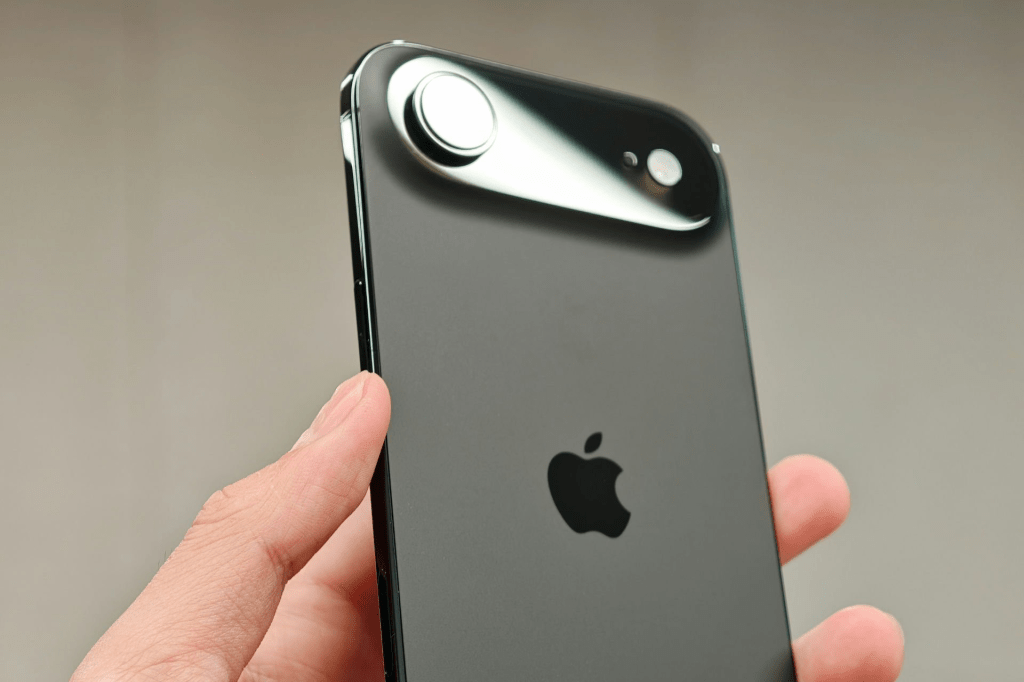 Close-up of an iPhone held in a person's hand, showcasing the sleek black design and camera module.