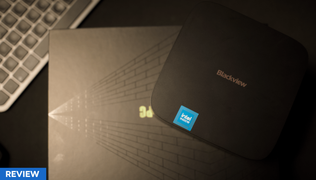 Vista superior de un Blackview MP60 Mini PC sobre su caja, con un teclado en el fondo.