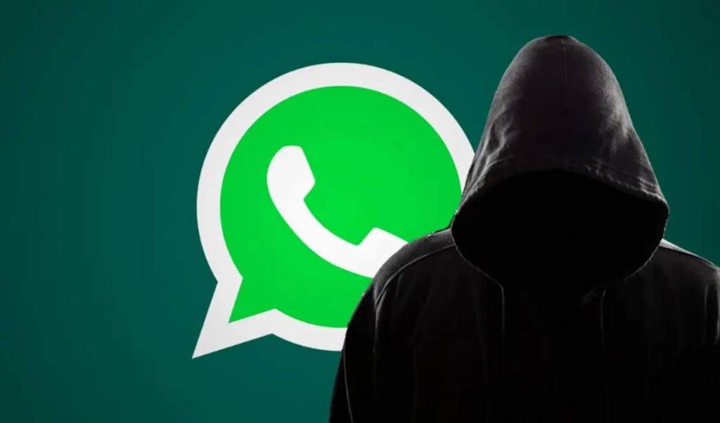 Persona en una sudadera con capucha frente al logo de WhatsApp en un fondo verde.