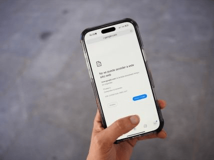 Un teléfono móvil en mano mostrando un mensaje de error de conexión a una página web.
