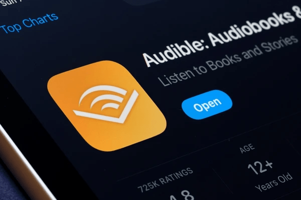 Icono de la aplicación Audible con la opción 'Abrir' para escuchar audiolibros y historias.