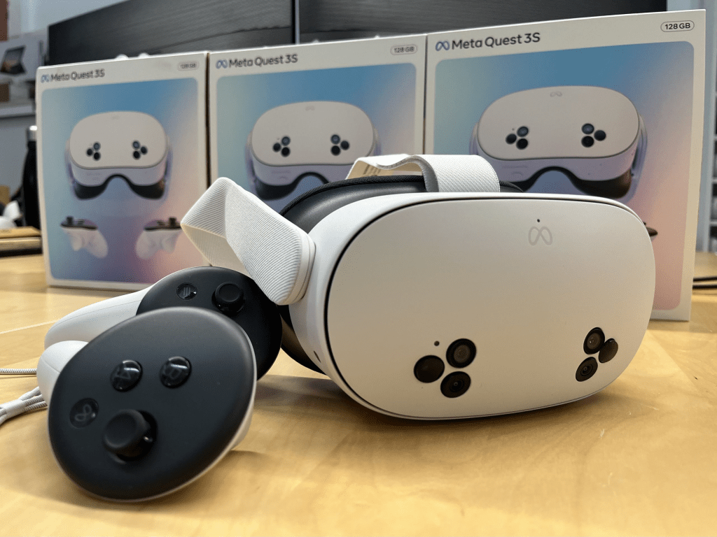 Auriculares de realidad virtual Meta Quest 3S y controladores, con cajas de fondo.