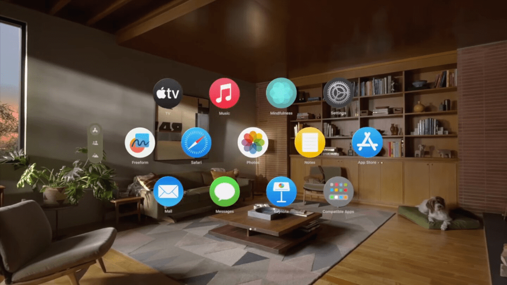 Interfaz de una sala de estar moderna con aplicaciones abiertas en pantalla, incluyendo TV, Música, Safari, Notas y la App Store. Se observa un perro descansando en una cama cerca de una mesa de centro.