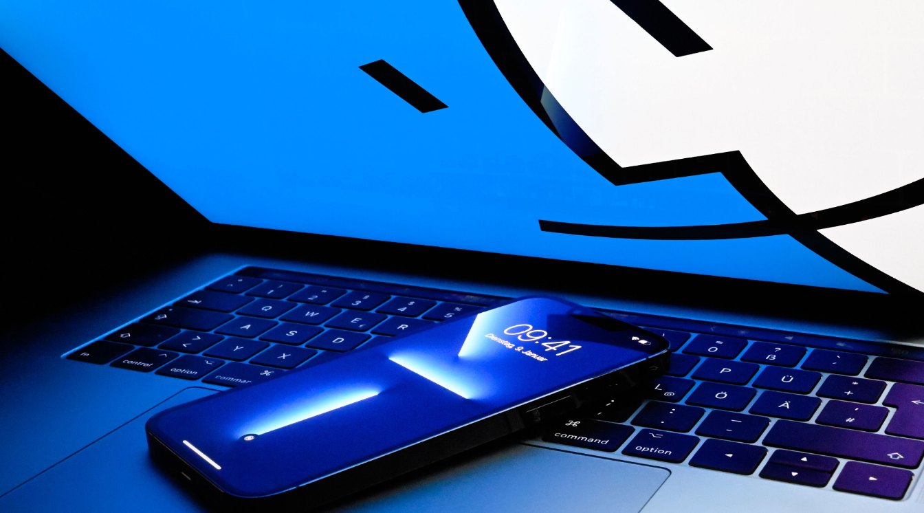 iPhone apoyado sobre un MacBook Pro, listo para hacer una copia de seguridad